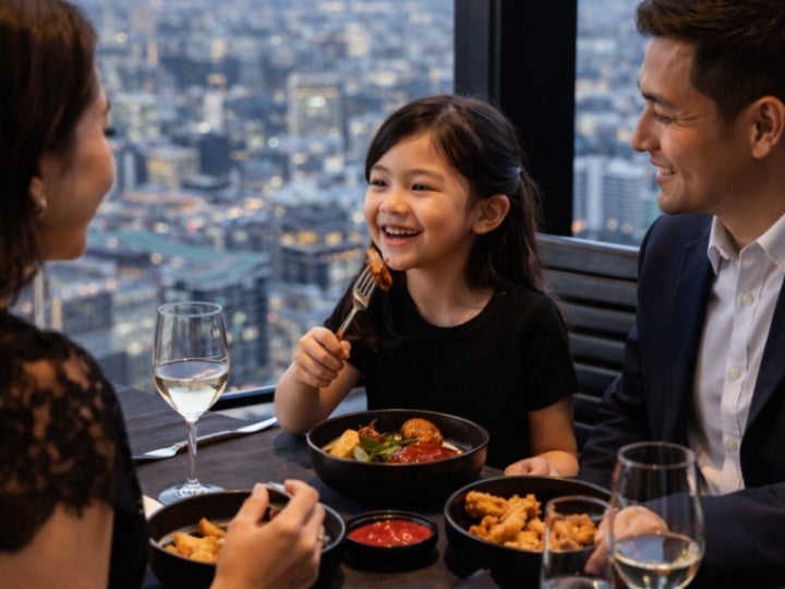 Happy family enjoying dinner at a sky-high restaurant in Melbourne | kid-friendly fine dining with panoramic city views