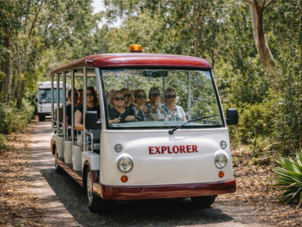 Tourists enjoying the Explorer tram ride through the lush bushland at Royal Botanic Gardens Cranbourne, Australia